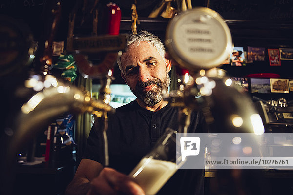 Mann beim Bierzapfen in einem irischen Pub
