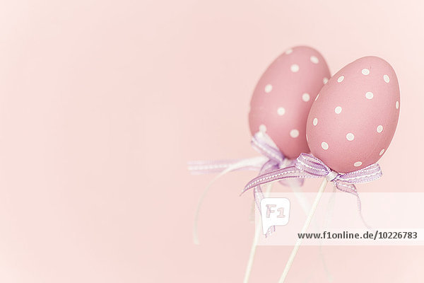 Pink plastic easter eggs before pink background