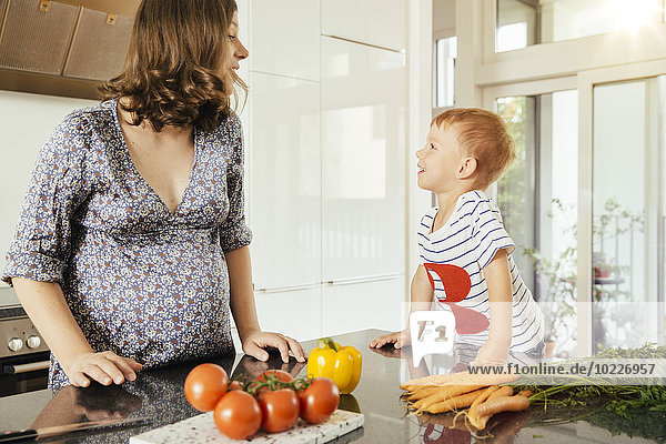 Schwangere Frau mit ihrem kleinen Sohn in der Küche