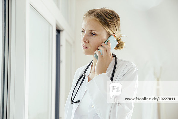 Serious female doctor on cell phone