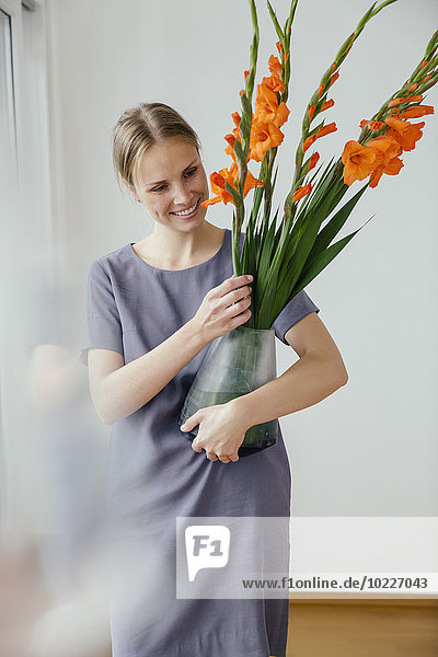 Woman holding a large vase with Gladiola