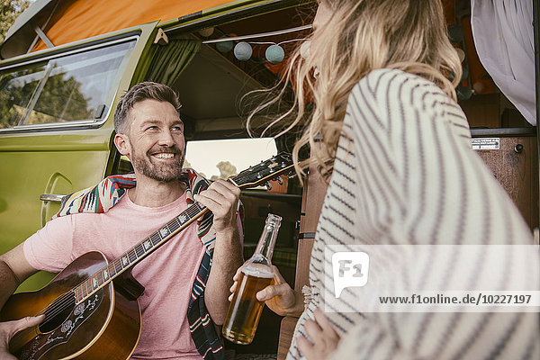 Glückliches Paar im Lieferwagen beim Musizieren