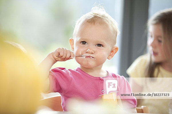 Baby Mädchen beim Joghurtessen