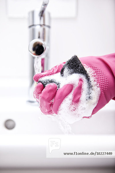 Frau Reinigung Bad Waschbecken mit Schwamm