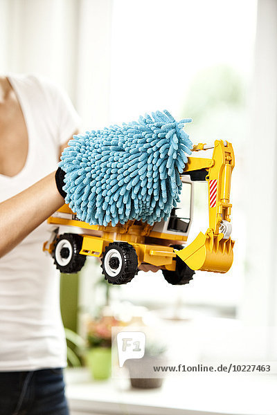 Woman dusting toy digger