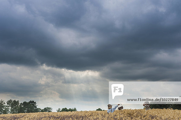 Germany  Saxony  two children standing in a grain field