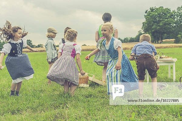 Germany  Saxony  children in traditonal clothes dancing on a meadow