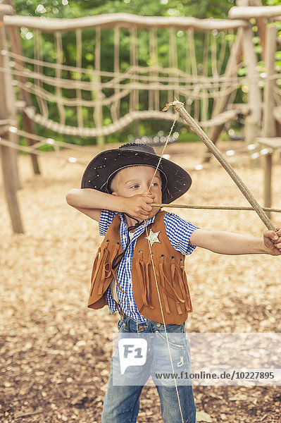 Deutschland  Sachsen  Indianer und Cowboy-Party  Junge spielt mit Pfeil und Bogen