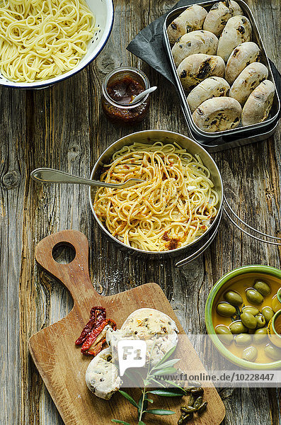 Spaghetti mit Tomatenpesto  Parmesan und selbstgemachten Brötchen aus Oliven und Tomaten auf Holzbrettchen