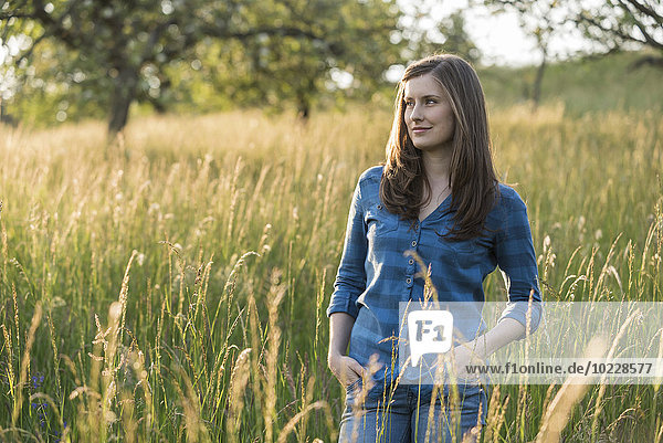 Junge Frau auf einem Feld am Abend