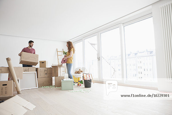 Young couple in new flat unpacking cardboard boxes