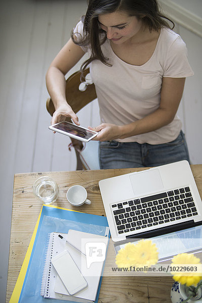 Junge Frau im Home-Office mit digitalem Tablett