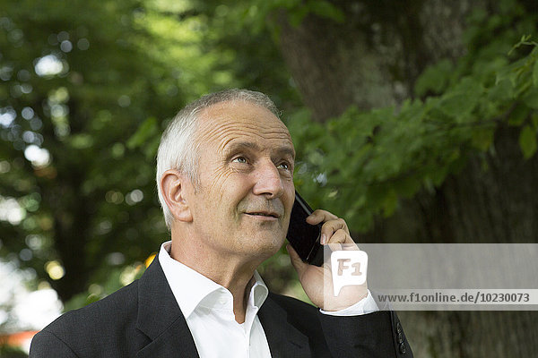 Portrait of businessman telephoning with smartphone