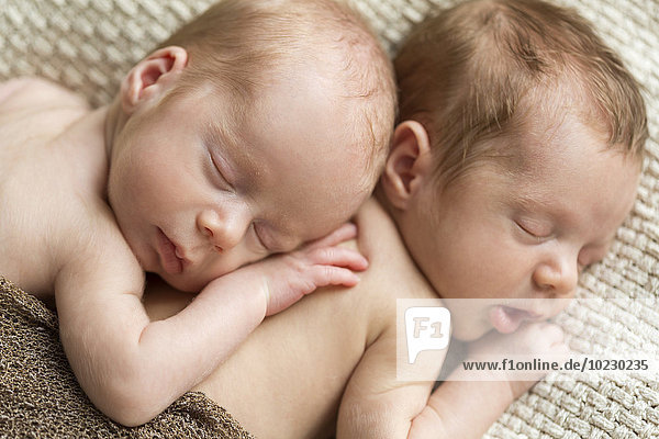 Porträt von neugeborenen Zwillingen  die auf einer Decke schlafen.