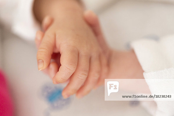 Neugeborene Zwillinge schlafen Hand in Hand  Nahaufnahme