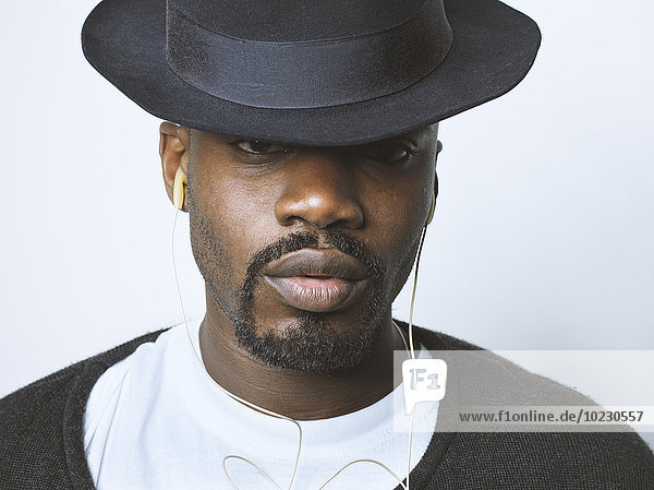 Portrait of young man with hat and earbuds