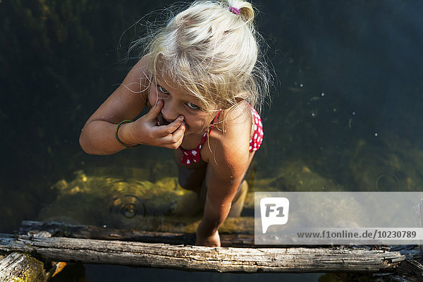 Girl getting into a lake