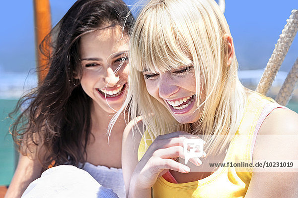 Zwei lachende junge Frauen auf einem Segelschiff