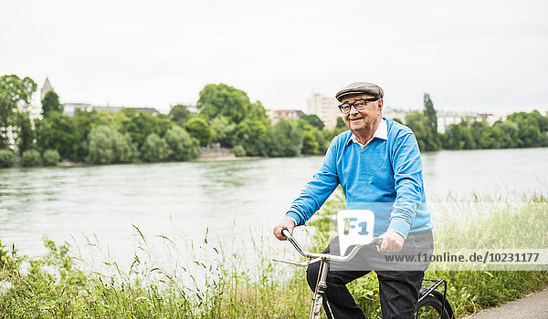 Lächelnder älterer Mann auf dem Fahrrad