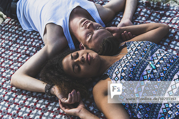 Entspanntes junges Paar auf der Decke liegend