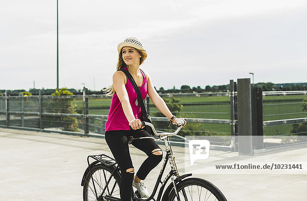 Teenage girl riding bicycle on parking level