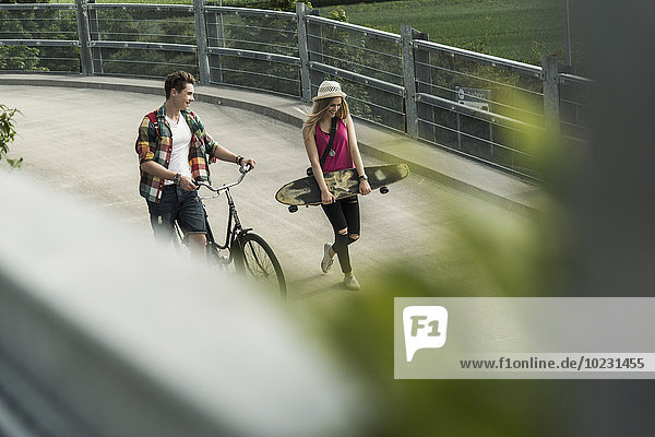 Junges Paar mit Fahrrad und Skateboard