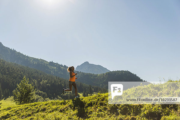Austria  Tyrol  Tannheim Valley  young woman jogging in alpine landscape