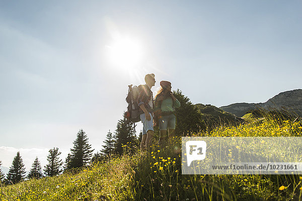 Austria  Tyrol  Tannheimer Tal  young couple standing on alpine meadow