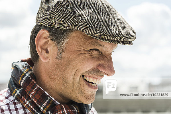 Erwachsener Mann lächelnd mit Mütze  Portrait