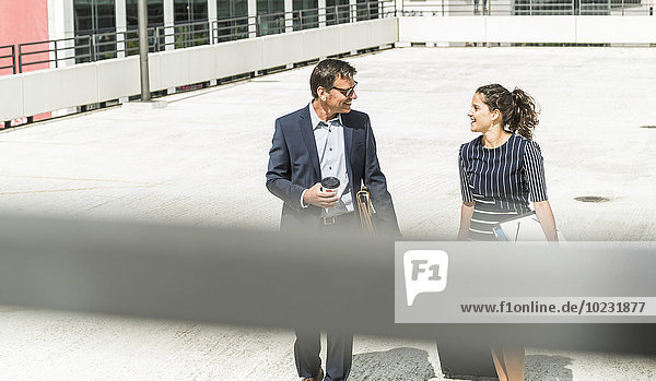 Erwachsener Geschäftsmann und junge Frau mit Laufkatze im Hof