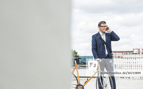 Geschäftsmann am Telefon  Fahrrad haltend