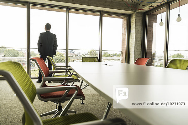Conference room with businessman at the window