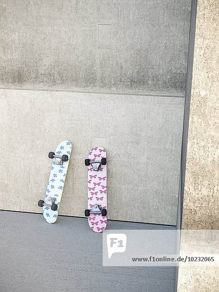 Two skateboards leaning on concrete wall  3D Rendering