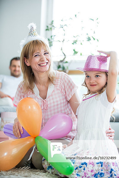Familienfeier mit Luftballons und Partyhüten