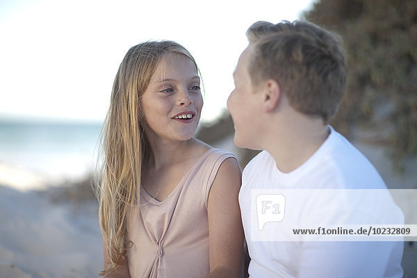 Smiling teenage boy and girl on beach