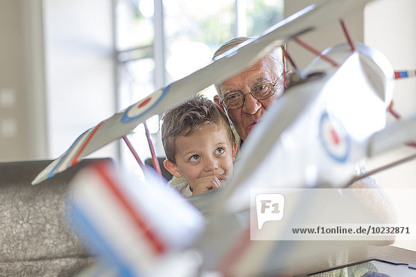 Großvater und Enkel beim Aufbau eines Modellflugzeugs