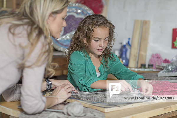 Mother and daughter doing crafts in home garage