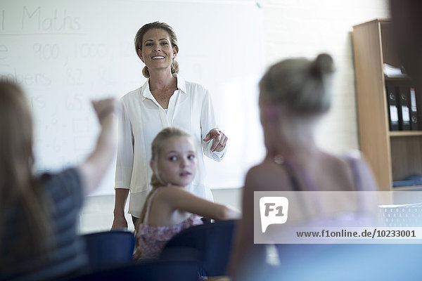Lehrer im Klassenzimmer beim Sprechen am Whiteboard