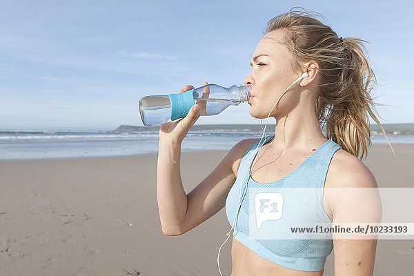 South Africa  Cape Town  young jogger drinking water from bottle