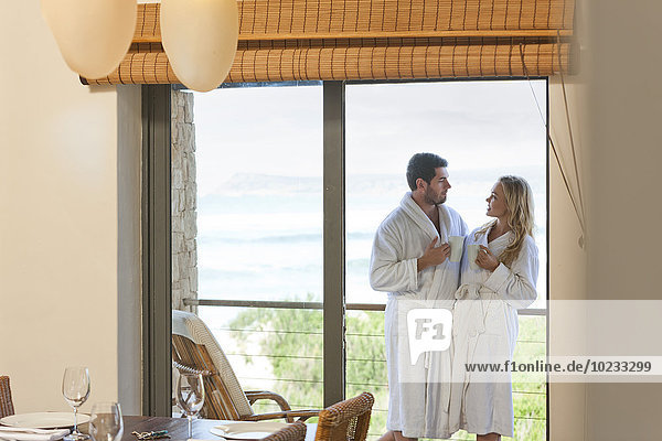 Young couple wearing bathrobes in beach house