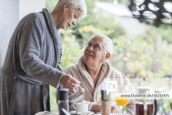 Senior couple having breakfast together on the terrace