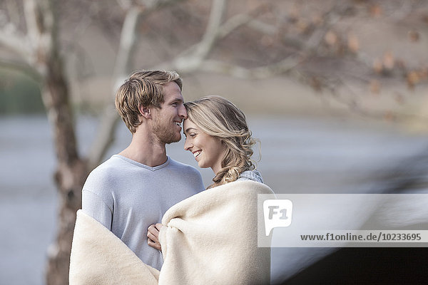 Junges Paar mit Decken am See