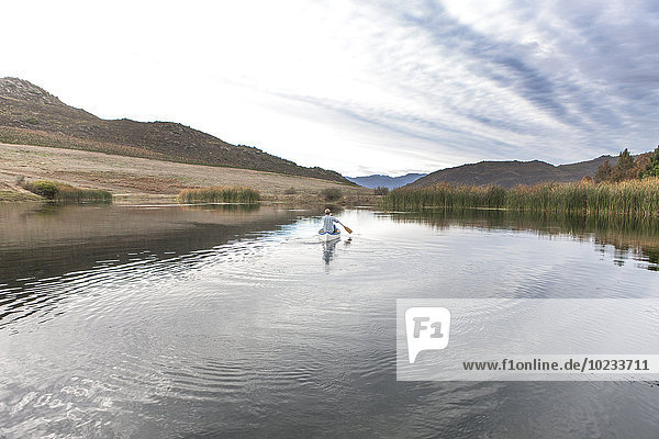 Young man paddling on a lake