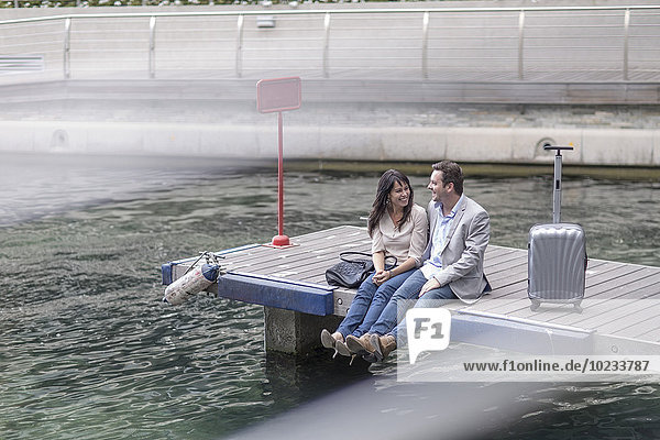 Man and woman sitting on a jetty