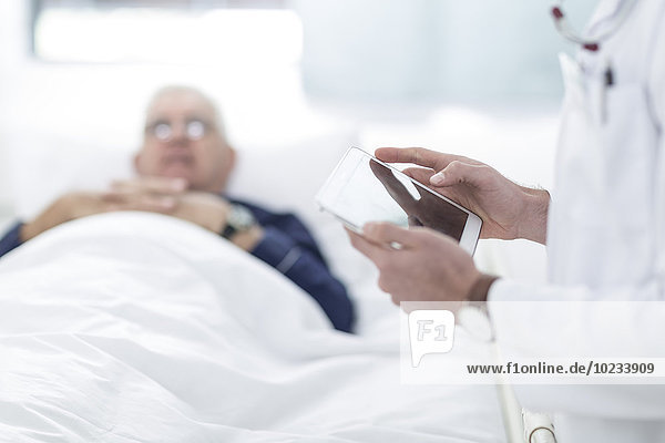 Nahaufnahme des Arztes mit einem digitalen Tablett neben dem Patienten