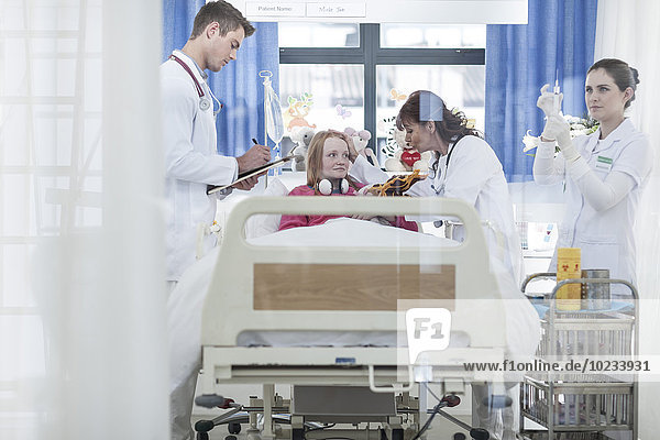 Ärzte untersuchen Mädchen im Krankenhausbett