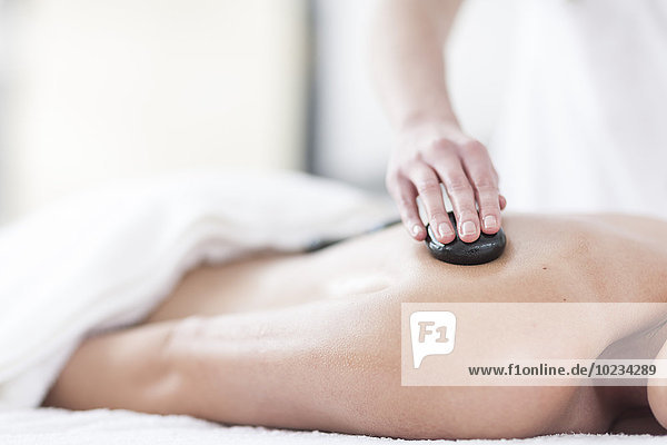 Woman receiving hot stone massage in a spa