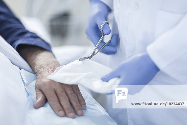 Krankenschwester reinigt Patientenhand vom Infusionstrichter