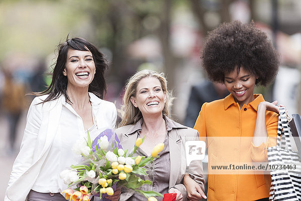 Porträt von drei glücklichen Frauen nebeneinander auf Einkaufstour