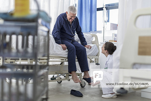 Krankenschwester für ältere Patienten im Krankenhausbett